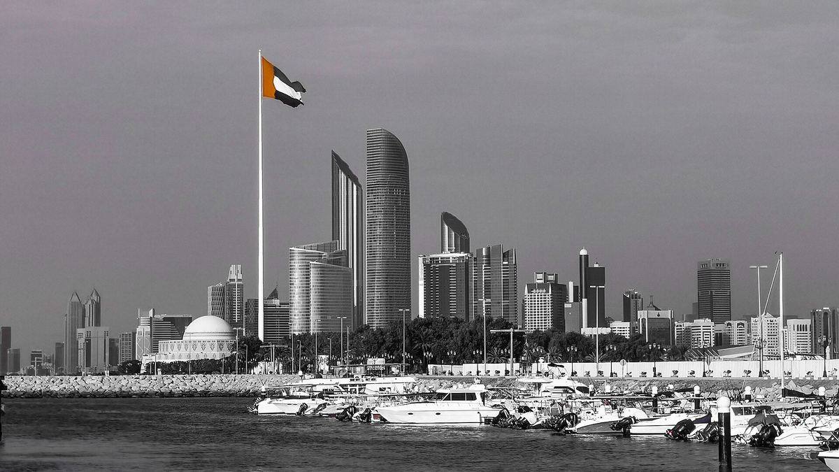 The Abu Dhabi skyline with the UAE flag, seen across a marina